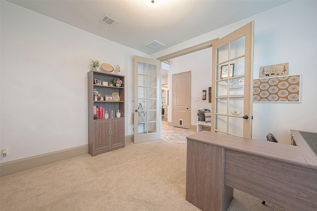 home office with french doors and light colored carpet