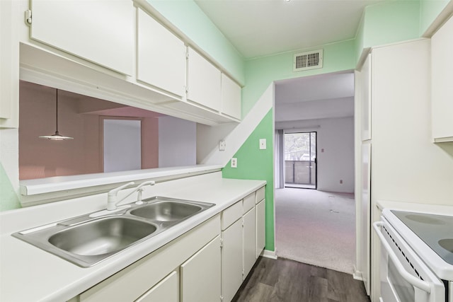 kitchen with dark wood-type flooring, electric stove, sink, decorative light fixtures, and white cabinetry