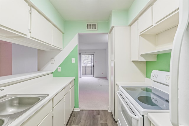 kitchen with sink, white electric range oven, refrigerator, wood-type flooring, and white cabinets