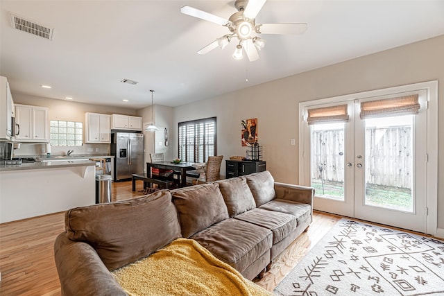 living room with french doors, light hardwood / wood-style floors, and ceiling fan