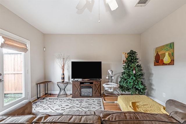 living room featuring ceiling fan, light hardwood / wood-style floors, and a wealth of natural light