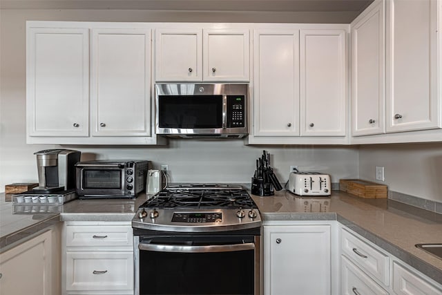 kitchen featuring stainless steel appliances and white cabinetry