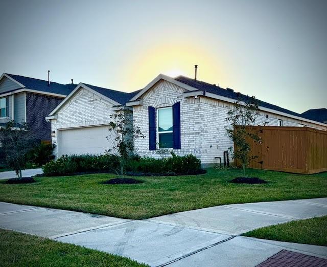 view of front of house with a garage and a yard