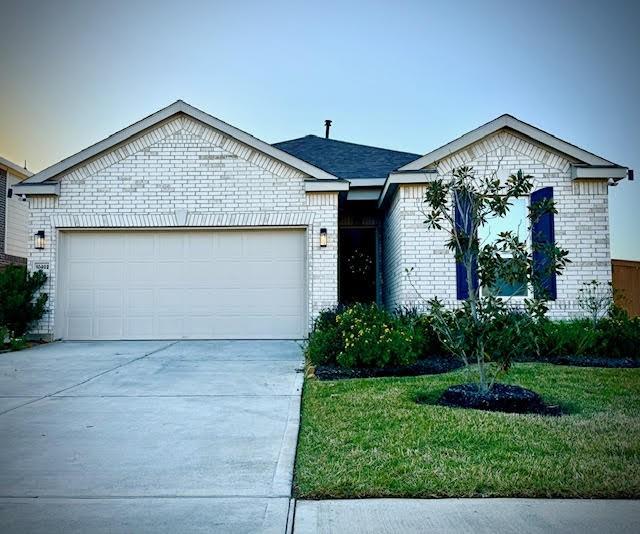 ranch-style house featuring a front yard and a garage