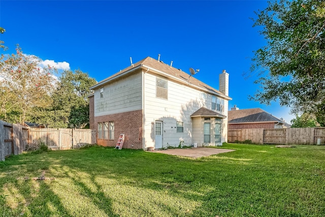 rear view of property with a lawn and a patio