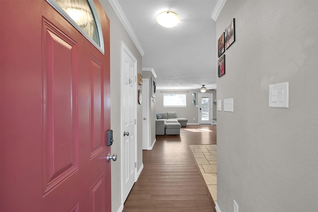 corridor featuring a textured ceiling, dark wood-type flooring, and crown molding