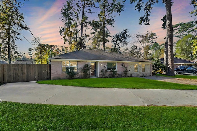 ranch-style home featuring a lawn