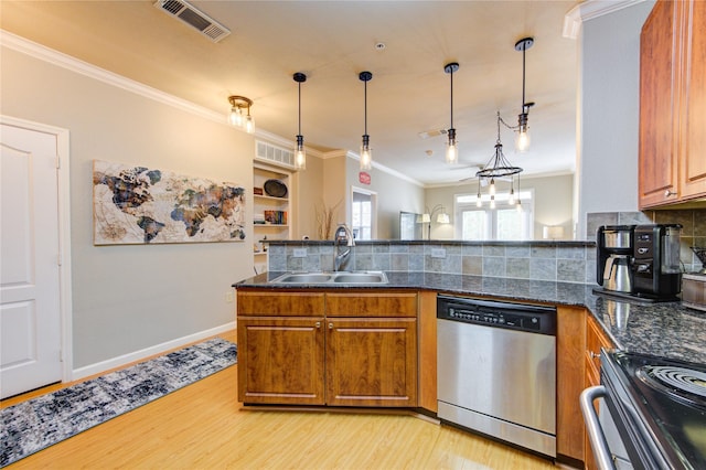 kitchen featuring appliances with stainless steel finishes, dark stone counters, ornamental molding, sink, and hanging light fixtures