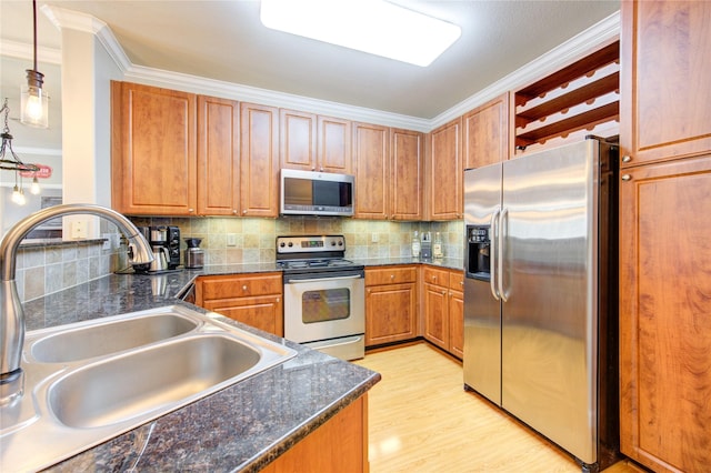 kitchen with backsplash, stainless steel appliances, crown molding, sink, and pendant lighting