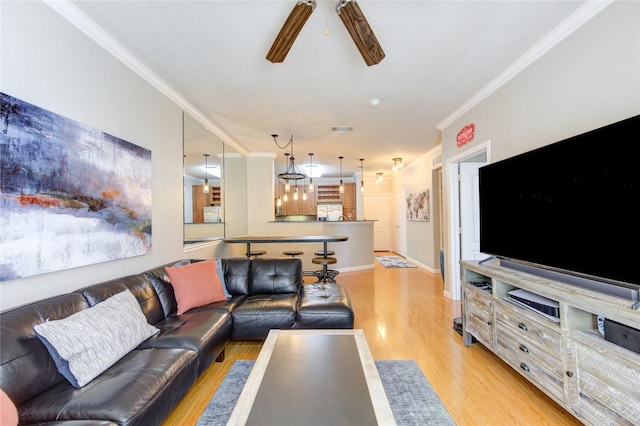 living room featuring ceiling fan, light hardwood / wood-style flooring, and ornamental molding