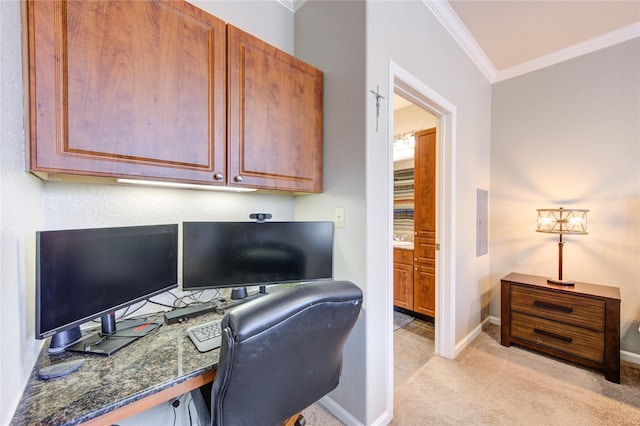 home office with built in desk, crown molding, and light carpet