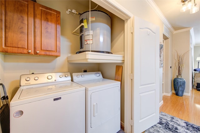 laundry area featuring cabinets, washing machine and dryer, water heater, crown molding, and wood-type flooring