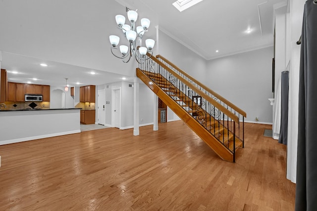 living room featuring a chandelier, light wood-type flooring, and crown molding