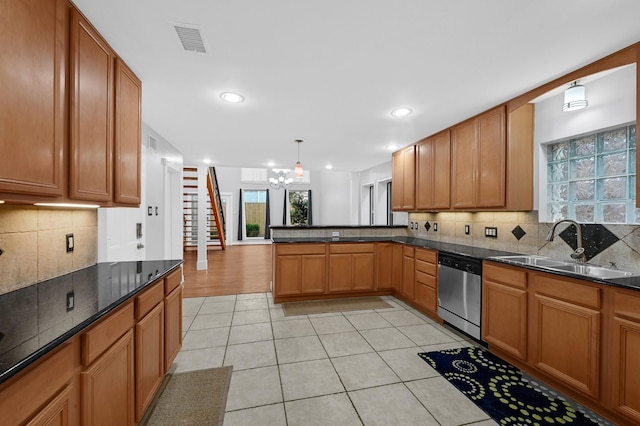 kitchen featuring sink, stainless steel dishwasher, decorative light fixtures, kitchen peninsula, and a chandelier