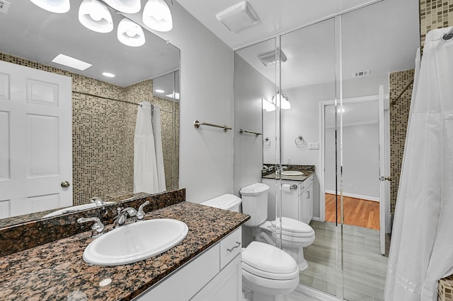 bathroom featuring a shower with shower curtain, vanity, and toilet