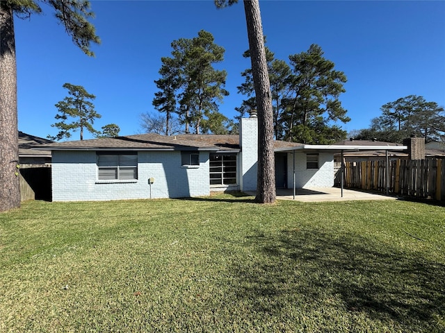 rear view of house with a patio and a yard