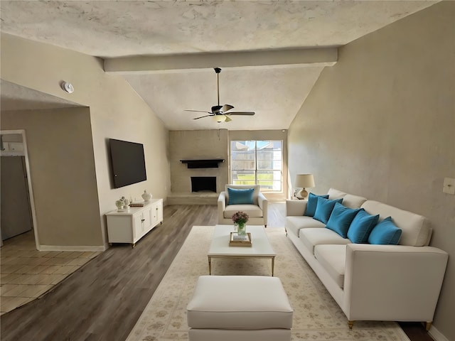 living room featuring hardwood / wood-style flooring, ceiling fan, and vaulted ceiling with beams