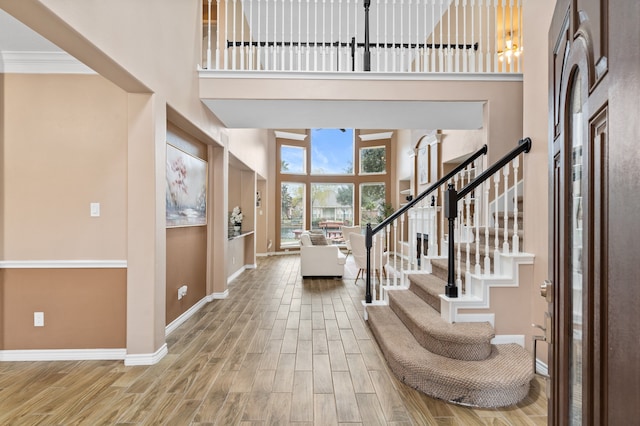 foyer entrance with a towering ceiling and ornamental molding