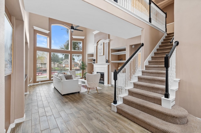 living room with ceiling fan and a high ceiling