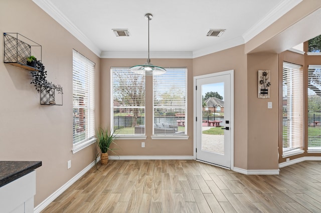 unfurnished dining area with light hardwood / wood-style floors and ornamental molding