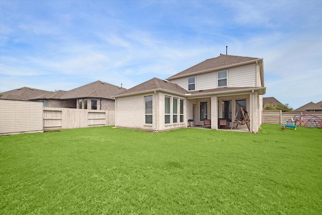 back of house with a lawn and a patio area