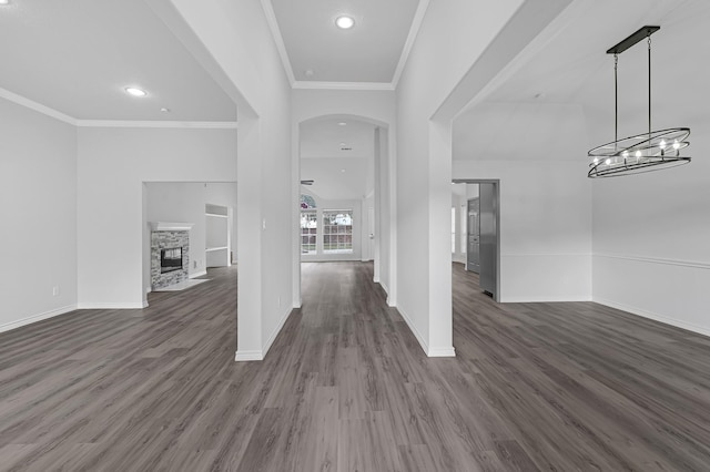 entrance foyer with dark hardwood / wood-style floors, crown molding, a fireplace, and an inviting chandelier