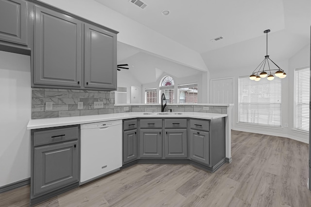 kitchen with ceiling fan, white dishwasher, lofted ceiling, gray cabinets, and decorative backsplash