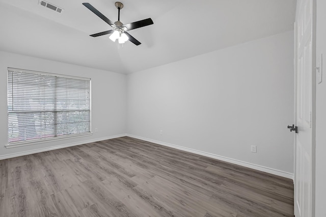 empty room with ceiling fan, vaulted ceiling, and hardwood / wood-style flooring