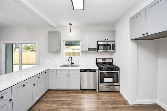 kitchen featuring appliances with stainless steel finishes, light stone countertops, sink, and plenty of natural light