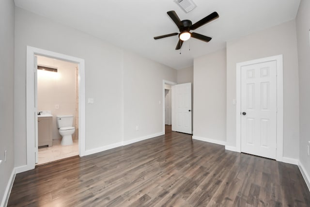 unfurnished bedroom featuring ceiling fan, ensuite bathroom, dark hardwood / wood-style flooring, and sink