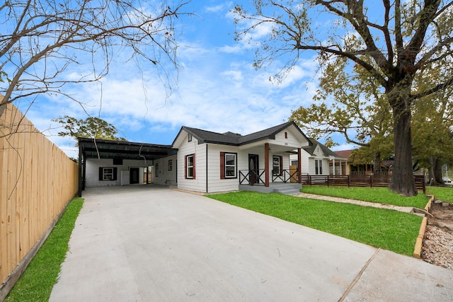 view of front facade with a carport, a porch, and a front lawn