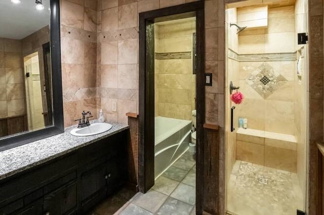 bathroom featuring vanity, shower / bath combination, and tile walls