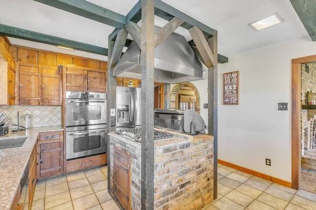 kitchen with appliances with stainless steel finishes, backsplash, and light tile patterned floors