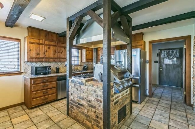 kitchen with backsplash, plenty of natural light, light tile patterned floors, and appliances with stainless steel finishes