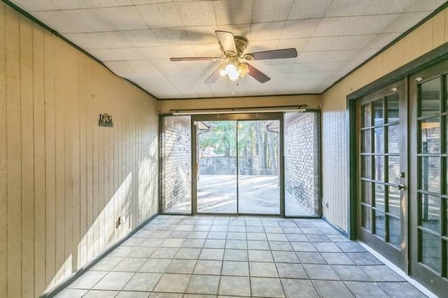 unfurnished sunroom featuring ceiling fan