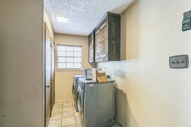 laundry room featuring washer and dryer, cabinets, and a textured ceiling