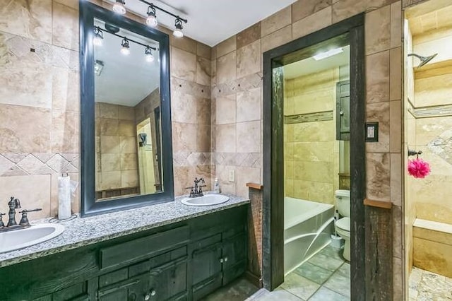 full bathroom with shower / bath combination, tile patterned floors, vanity, tile walls, and toilet