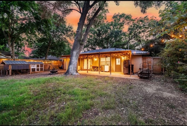 back house at dusk featuring an outdoor structure