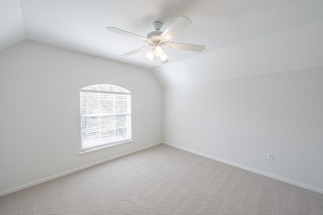 carpeted empty room featuring vaulted ceiling and ceiling fan