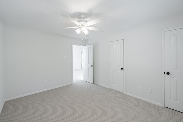 unfurnished bedroom featuring light colored carpet and ceiling fan