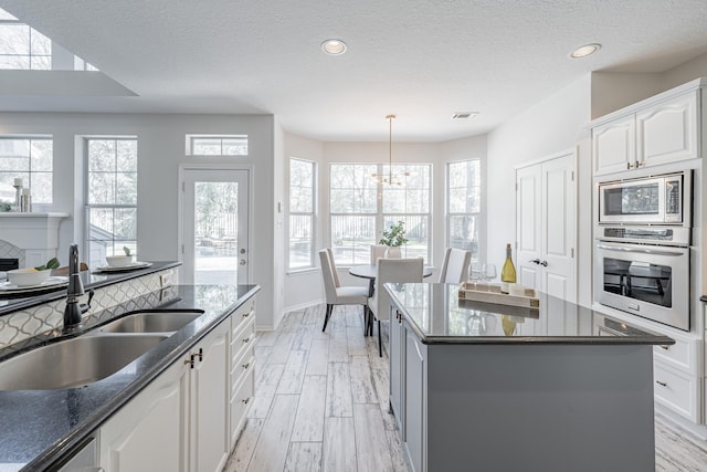 kitchen featuring white cabinetry, sink, a textured ceiling, and appliances with stainless steel finishes