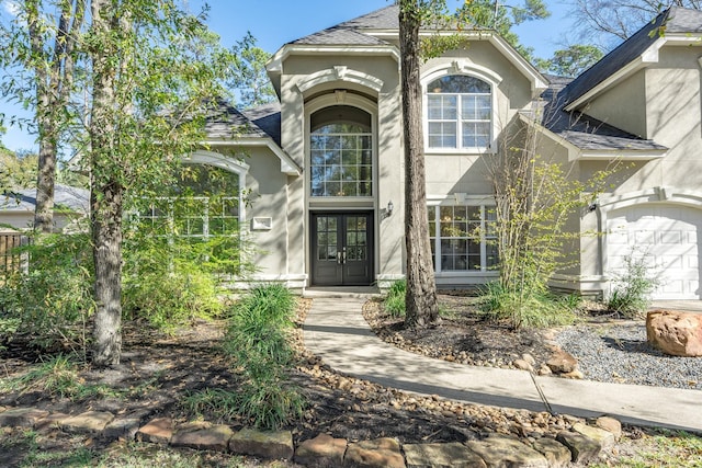 view of exterior entry featuring french doors and a garage