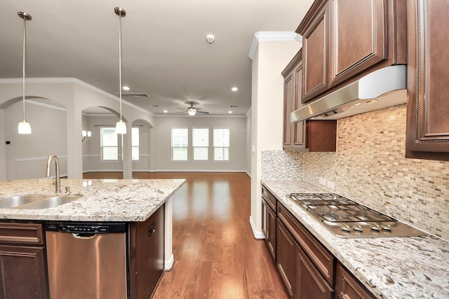 kitchen with pendant lighting, backsplash, sink, ceiling fan, and stainless steel appliances