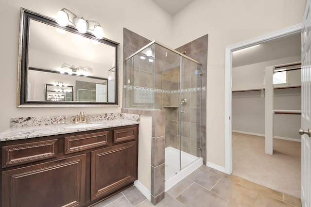 bathroom featuring tile patterned flooring, vanity, and walk in shower