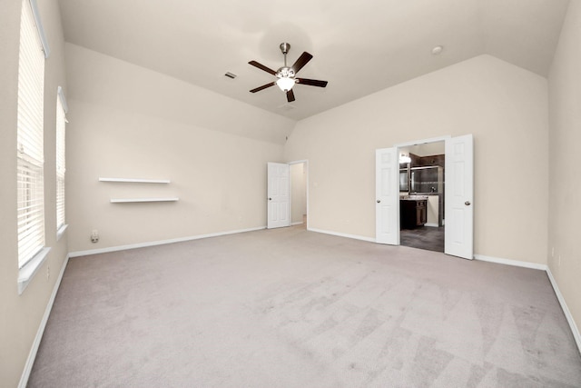 unfurnished bedroom featuring carpet, ensuite bathroom, ceiling fan, and lofted ceiling