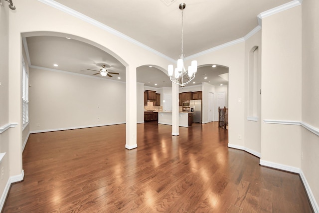 unfurnished dining area with ceiling fan with notable chandelier, dark hardwood / wood-style floors, and crown molding