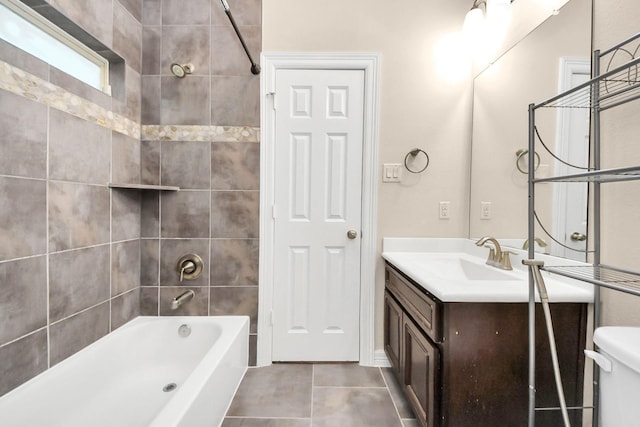 full bathroom with tile patterned floors, vanity, tiled shower / bath combo, and toilet