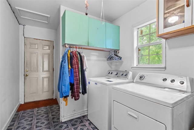 clothes washing area featuring cabinets and separate washer and dryer