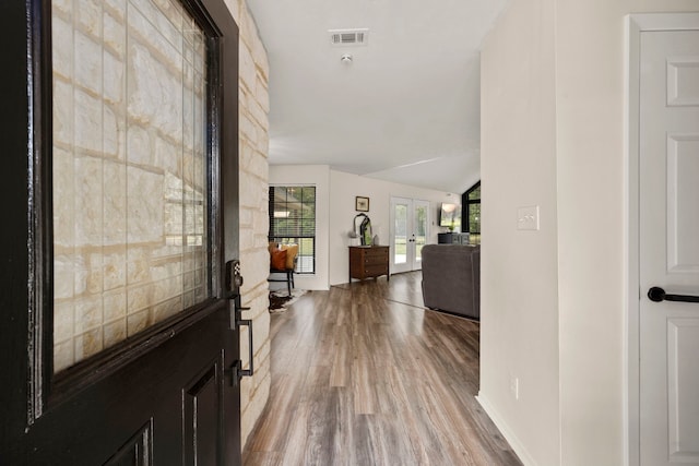 foyer entrance with french doors, vaulted ceiling, and hardwood / wood-style flooring