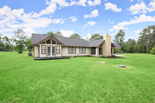 back of property featuring a yard and french doors